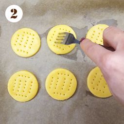 a person is using a fork to cut holes in the dough on top of each other