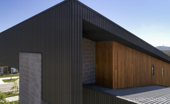 a building that is made out of metal and wood with a wooden door on the side