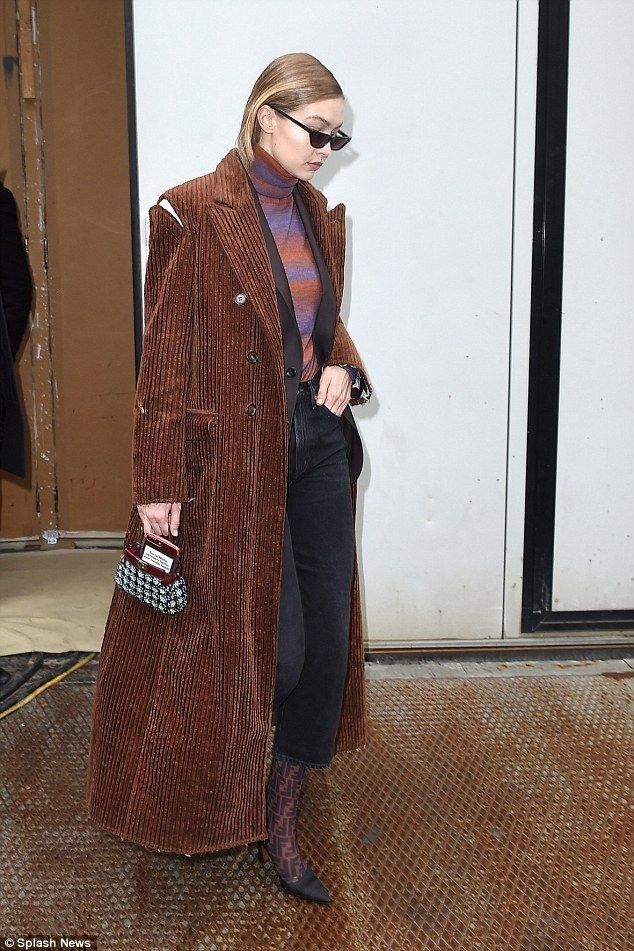 a woman in a brown coat and black pants