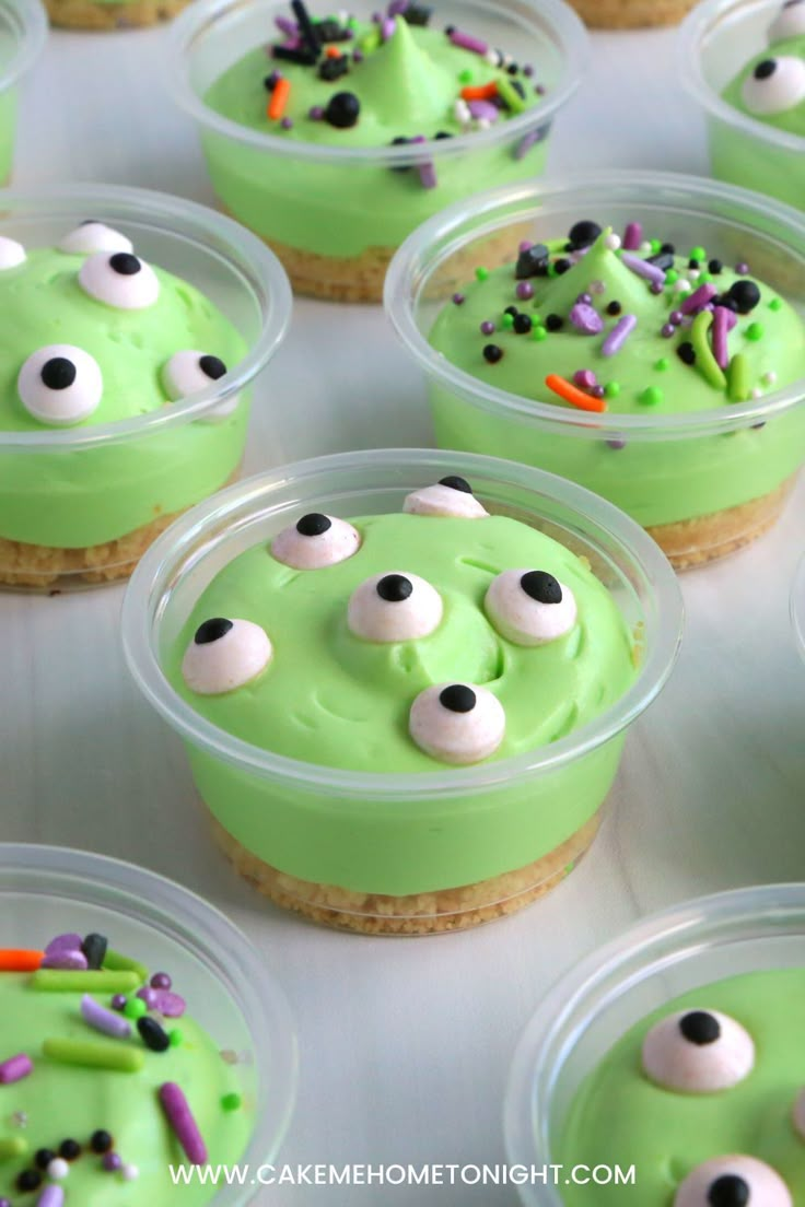 cupcakes decorated with green frosting and sprinkles in plastic containers