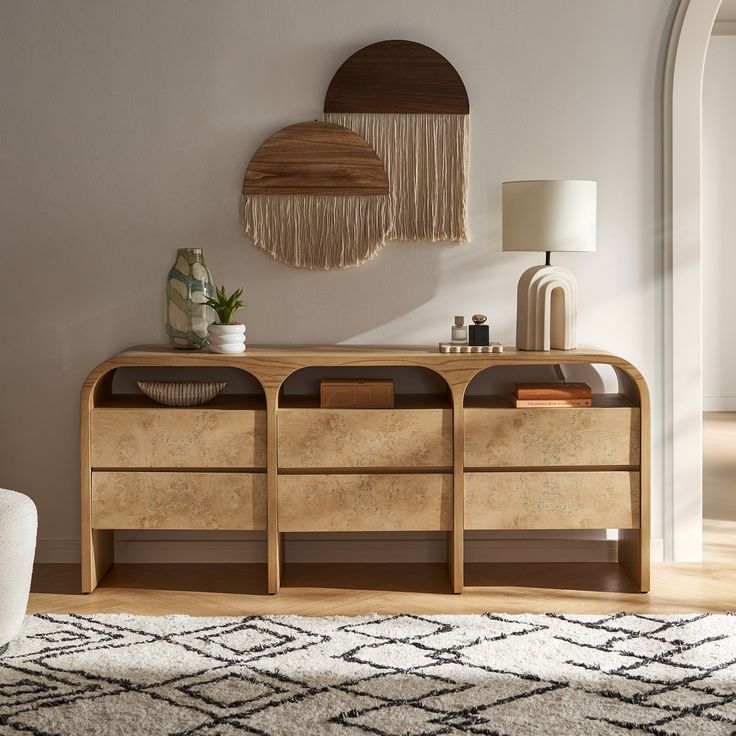 a living room with a rug, table and wall hangings