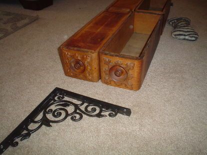 an old wooden box with two drawers on the floor next to a pair of shoes