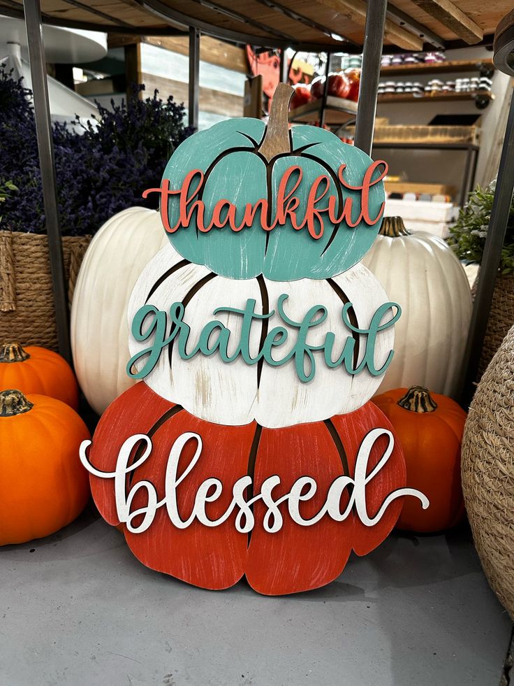 a wooden sign that says, thank grateful and pumpkins in front of some baskets