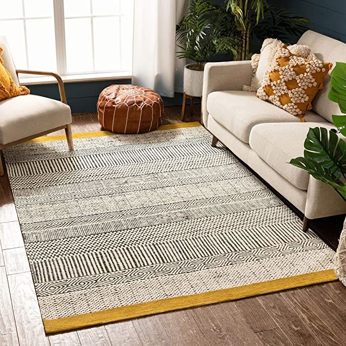 a living room area with two couches and a rug on the floor in front of a window