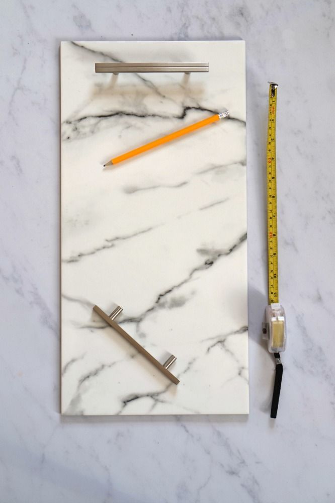 a marble board with pencils, ruler and eraser on it next to a tape measure