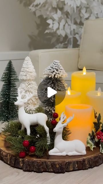 candles are sitting on a wooden tray with christmas decorations and deer figurines in front of them