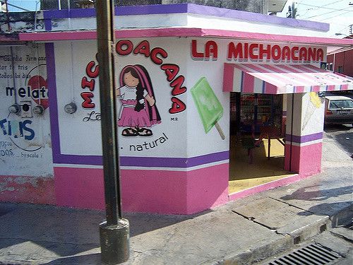 a pink and white building on the side of a street