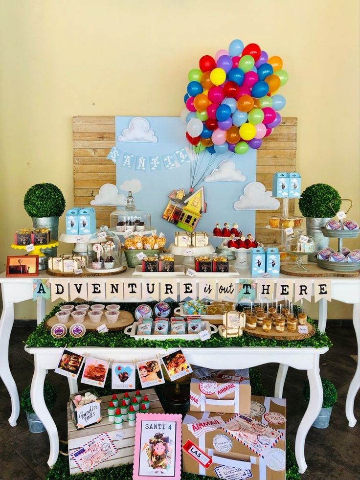 a table topped with lots of desserts and balloons