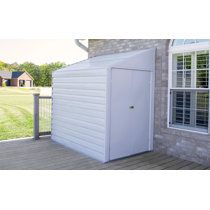 a white shed sitting on top of a wooden deck