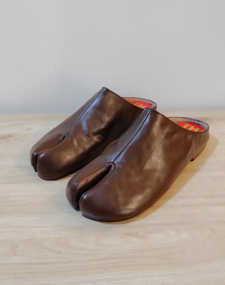 Beautiful handmade leather Japanese Tabi mules  with split toe design,completely hand stitched from top to bottom. The boots are made with soft supple leather and are very comfortable and will mold to your foot with time. Pre order: Please note these mules are made upon order and will take 4-6 weeks to complete and ship. Handmade with top quality materials and stacked leather soles. The shoes will have minor imperfections do to handmade handling and painting. Sizes: 7-11 or 37-41 Please contact Leather Mules With Plain Toe And Leather Sole, Brown Open Toe Mules With Stitched Sole, Brown Mules With Single Toe Strap And Rubber Sole, Brown Mules With Rubber Sole And Single Toe Strap, Leather Mules With Plain Toe And Stitched Sole, Leather Mules With Stitched Plain Toe, Leather Mules With Stitched Sole And Plain Toe, Leather Mules With Plain Toe And Leather Lining, Brown Mules With Leather Footbed And Single Toe Strap