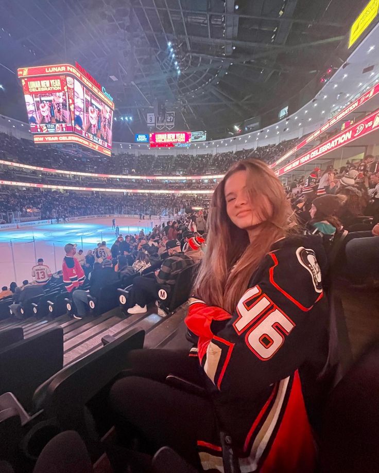 a woman sitting in the stands at a hockey game