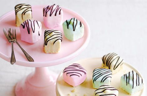 small desserts are arranged on a pink plate