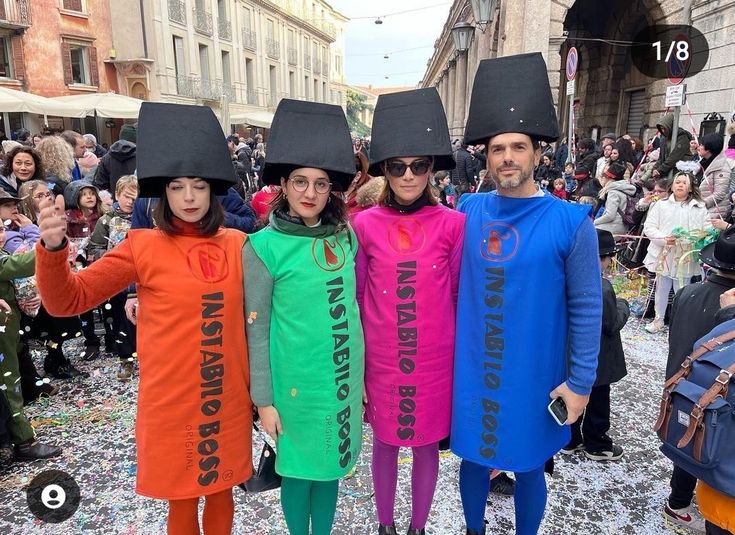 three people dressed in costumes and hats standing next to each other on a cobblestone street