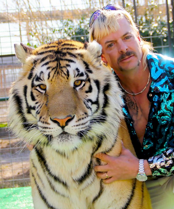 a man holding a large tiger in front of other people on the street and an image of a woman standing next to him