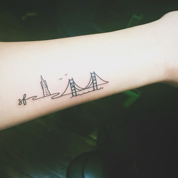 a person's arm with a bridge tattoo on it