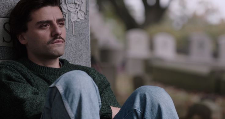 a man sitting on the side of a cement wall