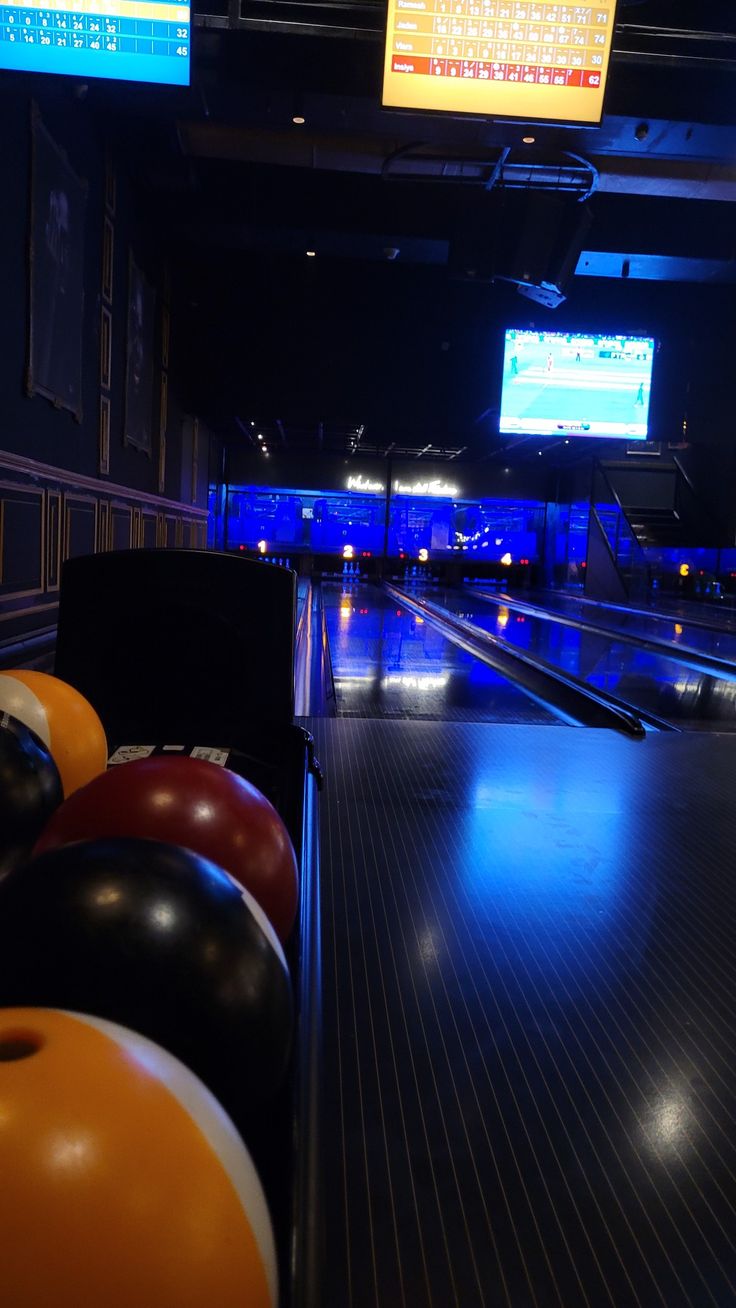 bowling balls are lined up in a row at the end of an indoor bowling alley