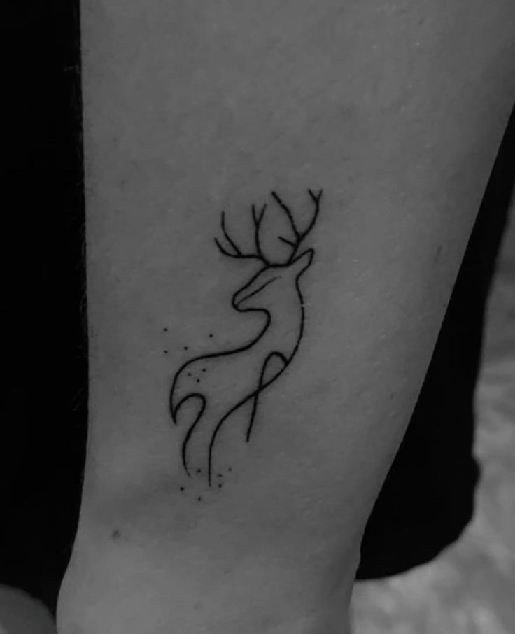 a black and white photo of a deer tattoo