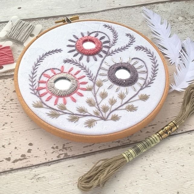 an embroidery project with flowers and feathers on it