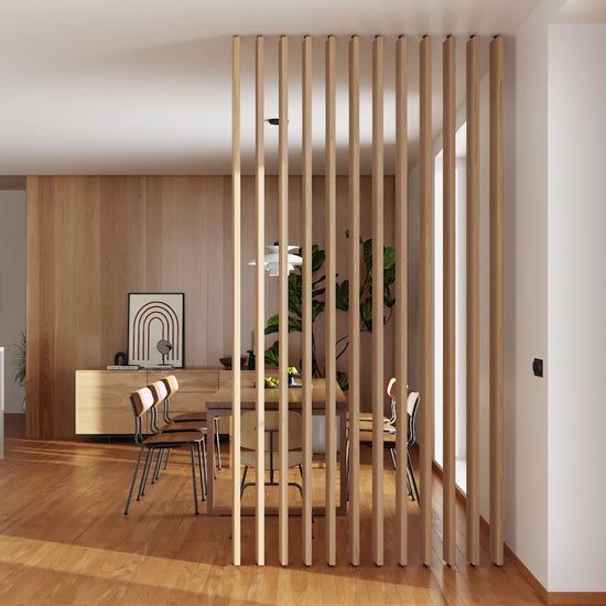 a room divider in the middle of a wooden floor with chairs and tables around it