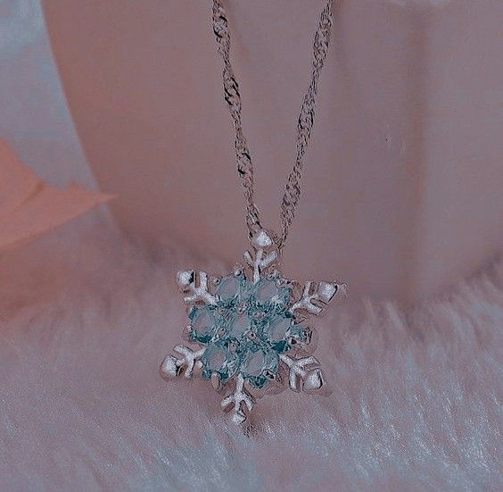 a snowflake necklace is shown on a fur surface