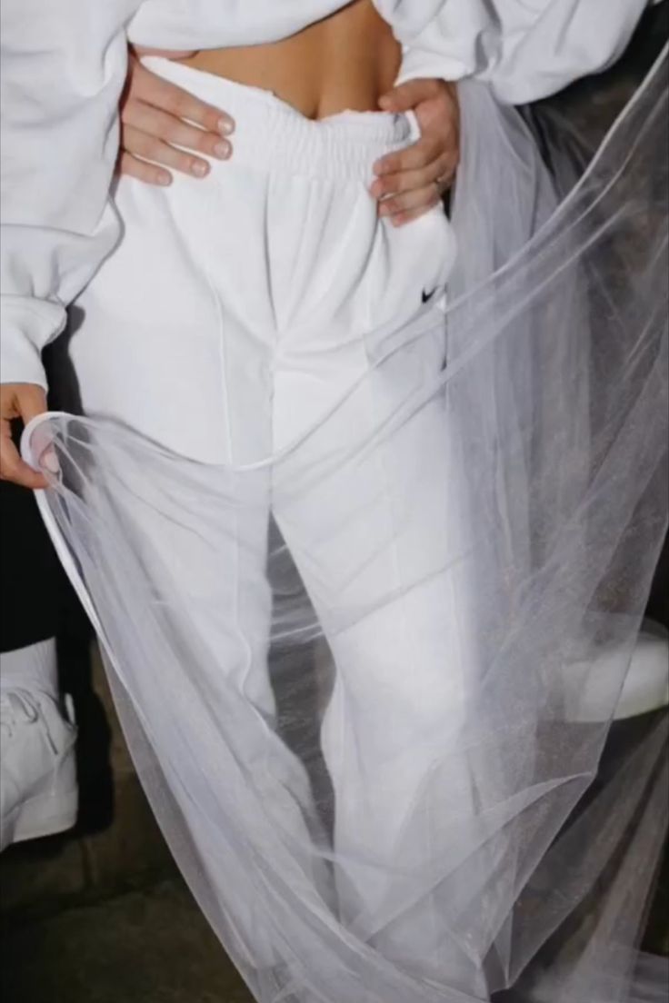 a woman wearing white pants and a veil on her stomach is seen from the waist down