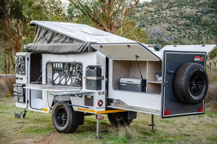 an off - road camper trailer is parked in the grass