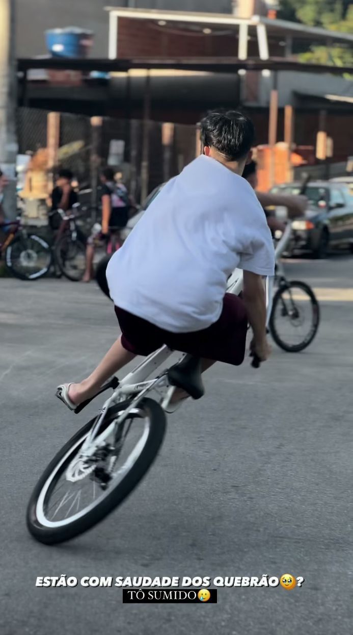 a man riding a bike down the middle of a street next to other people on bicycles