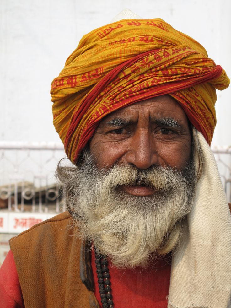 an old man with a yellow turban on his head and red scarf around his neck