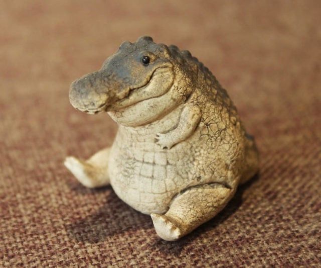 a small toy alligator sitting on the floor