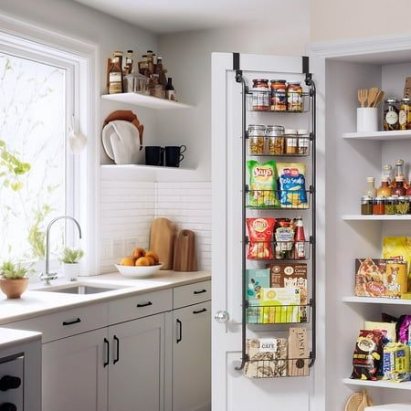 an open pantry door in a kitchen with lots of food on the shelves next to it