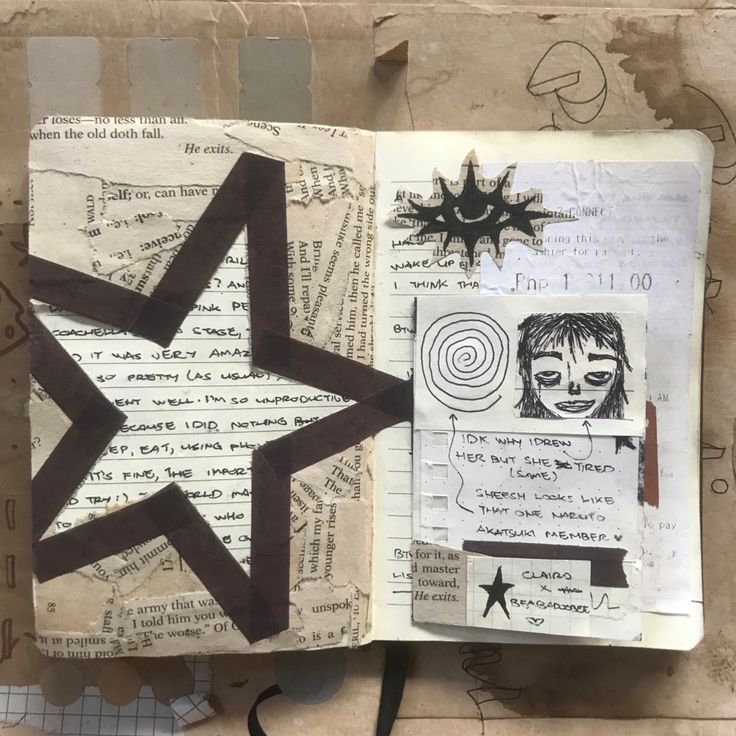 an open book with drawings on it and a star in the middle, next to scissors