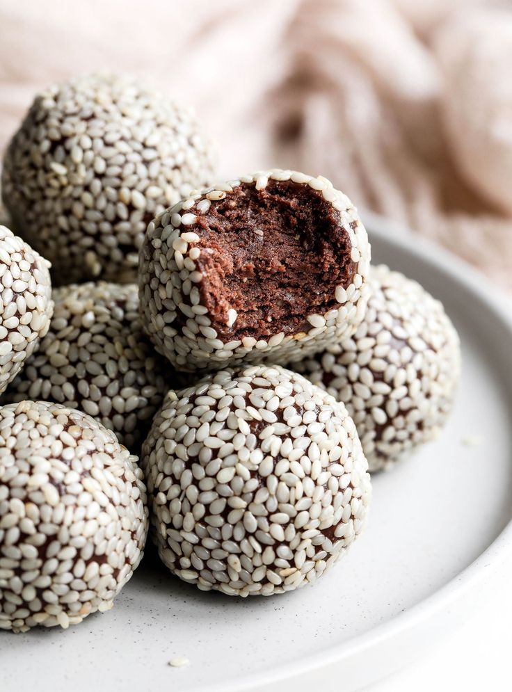 a white plate topped with chocolate truffles covered in sprinkles on top of a table