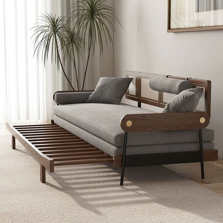 a living room with a futon bed and a plant in the corner next to it