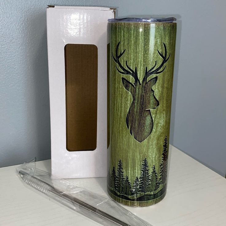 a cup with a deer head on it next to a cardboard box