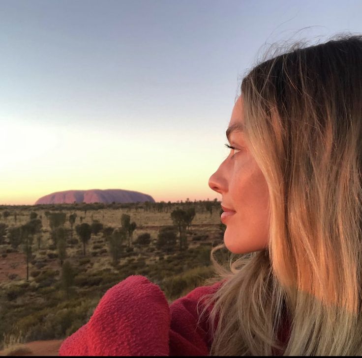 a woman looking out over the desert at sunset