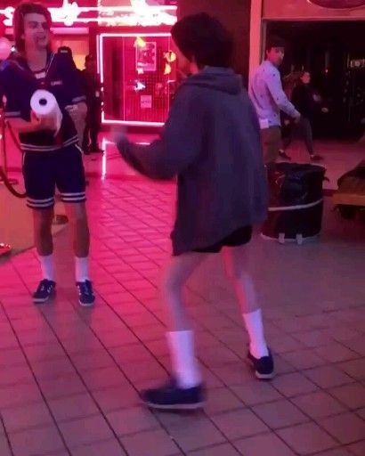 two young boys are playing with a soccer ball in the middle of an indoor mall