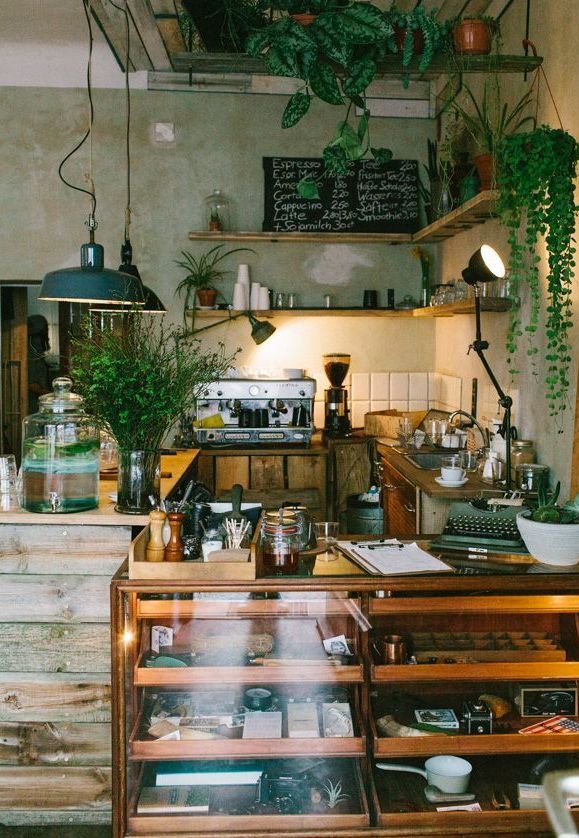 an old fashioned coffee shop with lots of potted plants