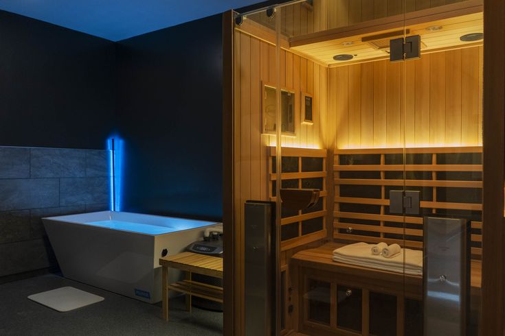 a bathroom with a sauna in the middle and blue light coming from it's side