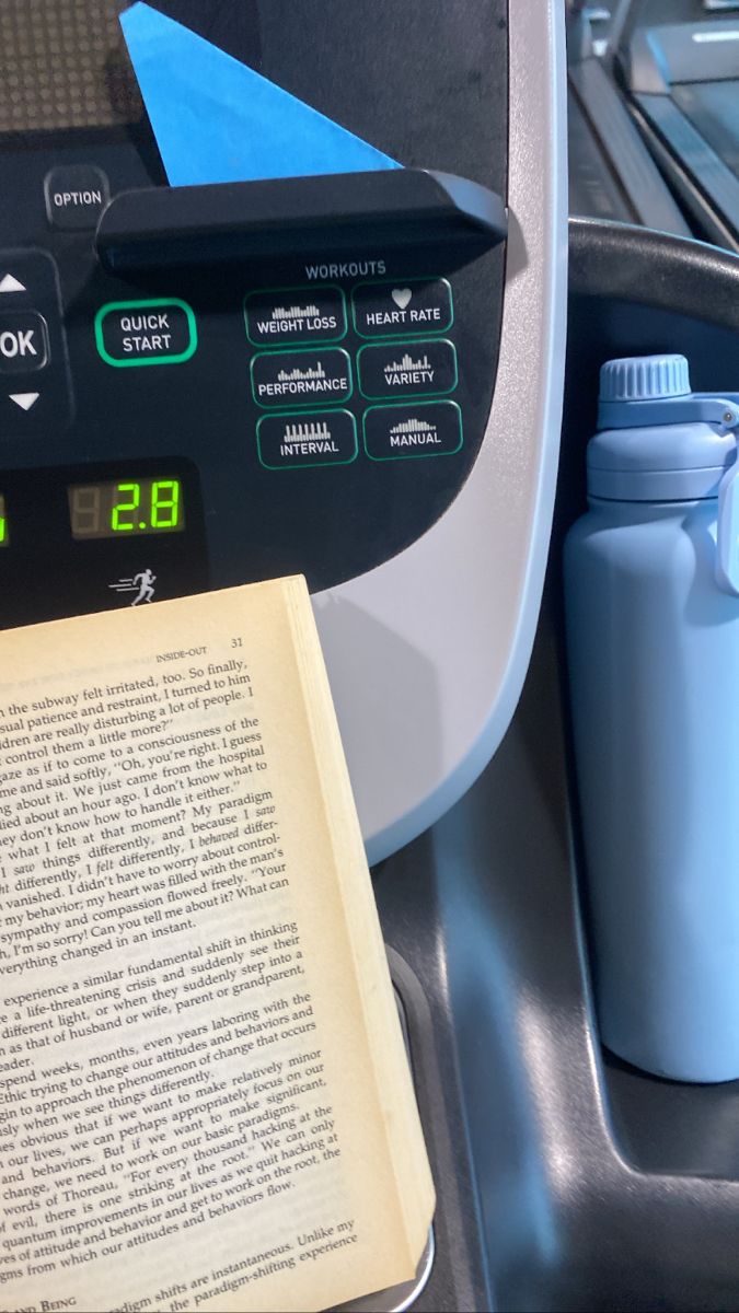 an open book sitting on top of a table next to a water bottle and a thermos