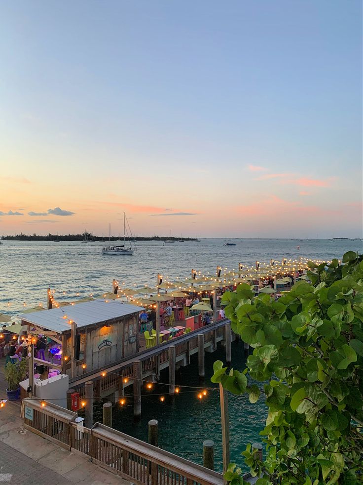 a pier filled with lots of tables next to the ocean