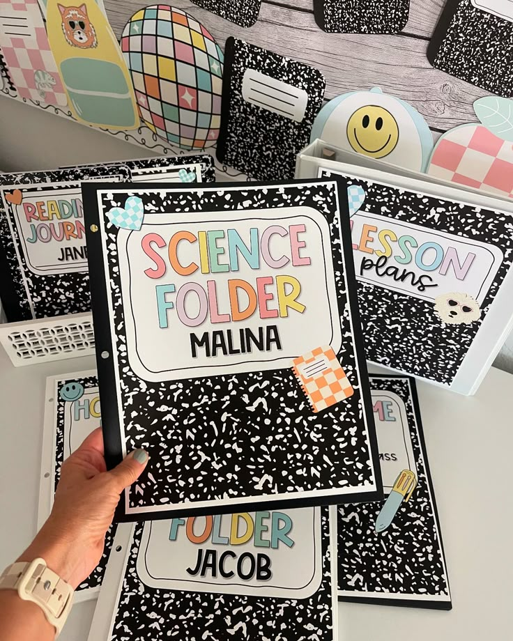 someone is holding up their science folders in front of some other items on the table