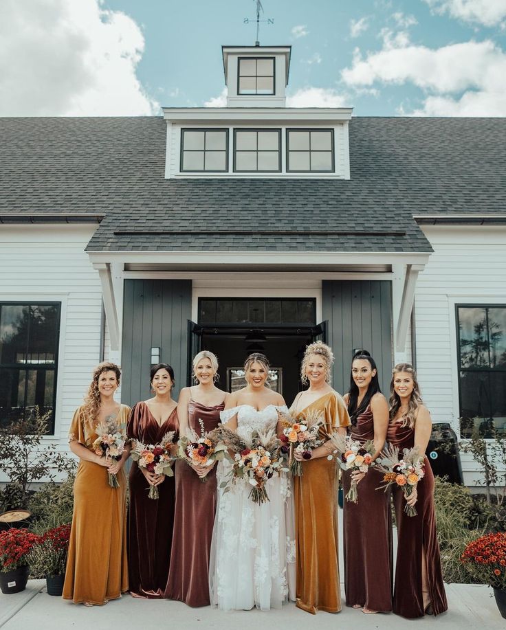 a group of women standing next to each other in front of a house