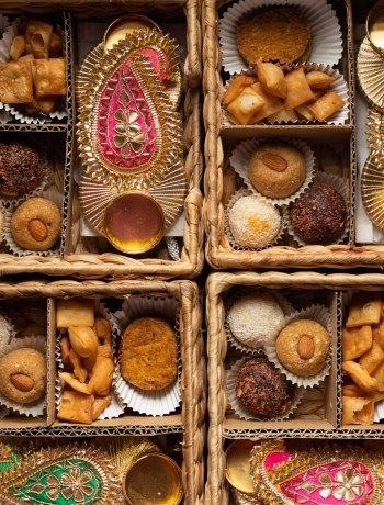 several boxes filled with assorted pastries in different colors and designs on top of each other