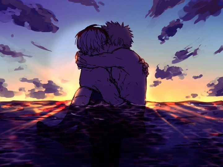 two people sitting in the water with their backs to each other as the sun sets