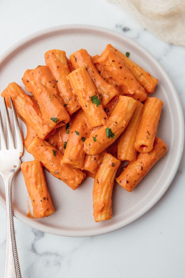 a white plate topped with pasta covered in sauce