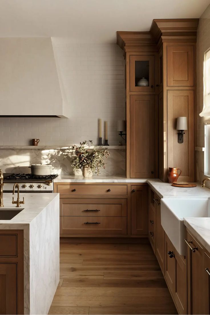 a kitchen filled with lots of wooden cabinets and white counter tops next to a stove top oven