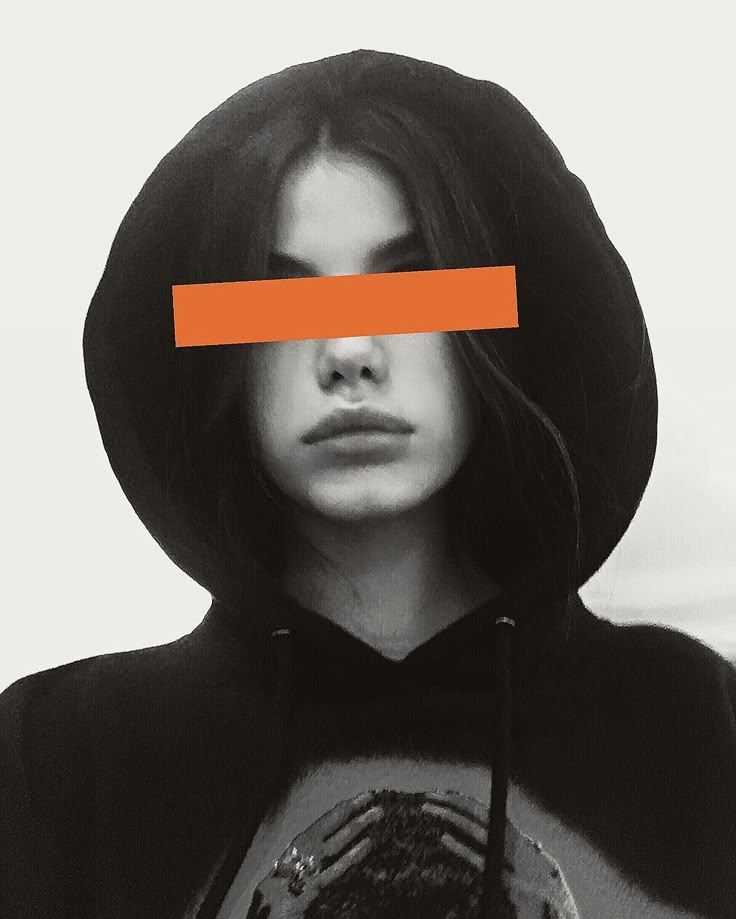 a woman wearing a hoodie with an orange strip across her face and behind her head