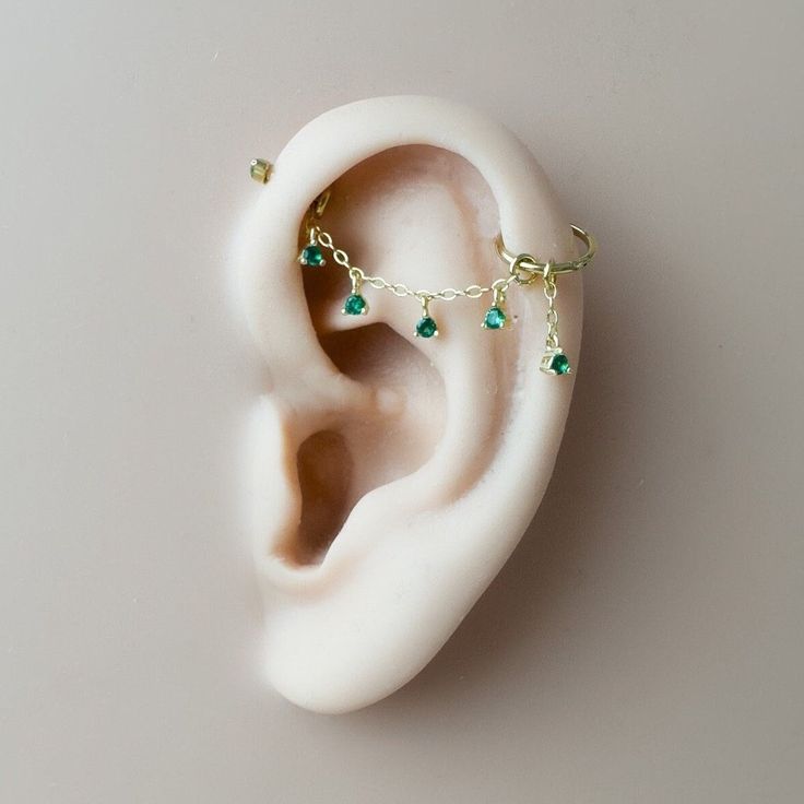 a fake ear with some green beads attached to it