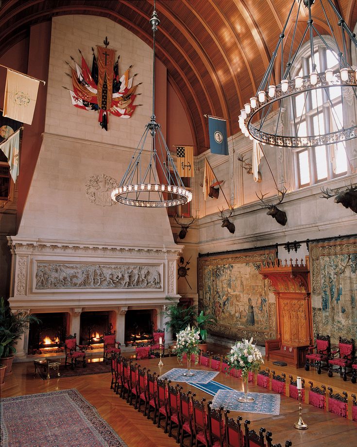 a large room with many chairs and tables in front of a fire place on the wall